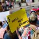 A demonstrator holds a placard stating “I WILL NOT COMPLY” during a rally outside the Pennsylvania Capitol Building regarding the continued closure of businesses due to the coronavirus pandemic on May 15, 2020 in Harrisburg, Pennsylvania. Pennsylvania Governor Tom Wolf has introduced a color tiered strategy to reopen the state with most areas not easing restrictions until June 4.